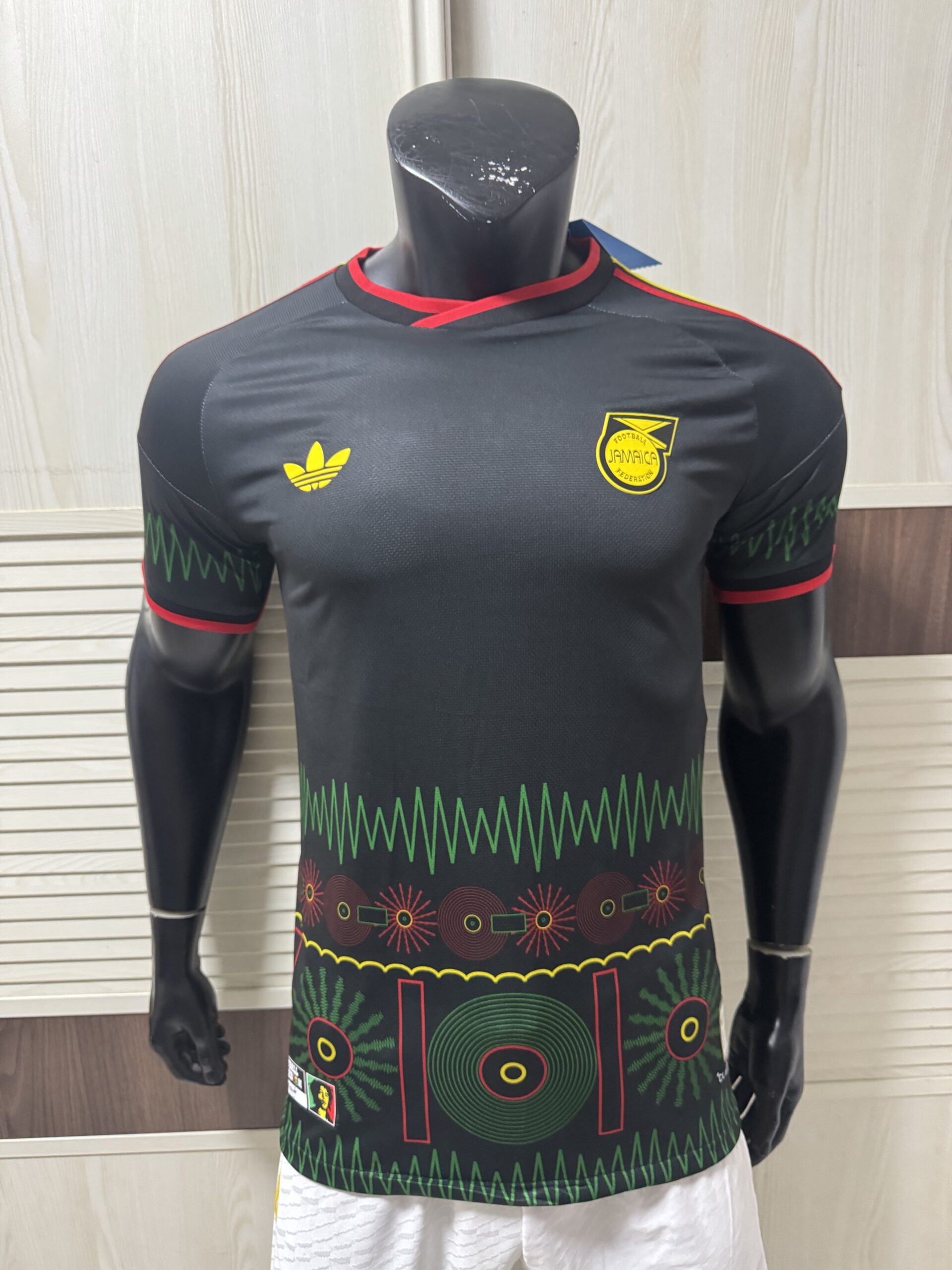 Adidas Jamaica 2026 x Bob Marley Away Replica Jersey black Reggae Boyz official replica kit front view showing striking black design with Bob Marley tribute details and Football Is Freedom inscription